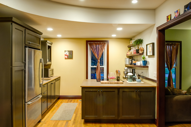 Kitchen after - this cozy kitchen, highlighted by a curved soffit, packs in a surprising amount of storage and usable work space.