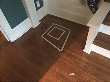 Tape on floor marks area where sculpture will site on its new base