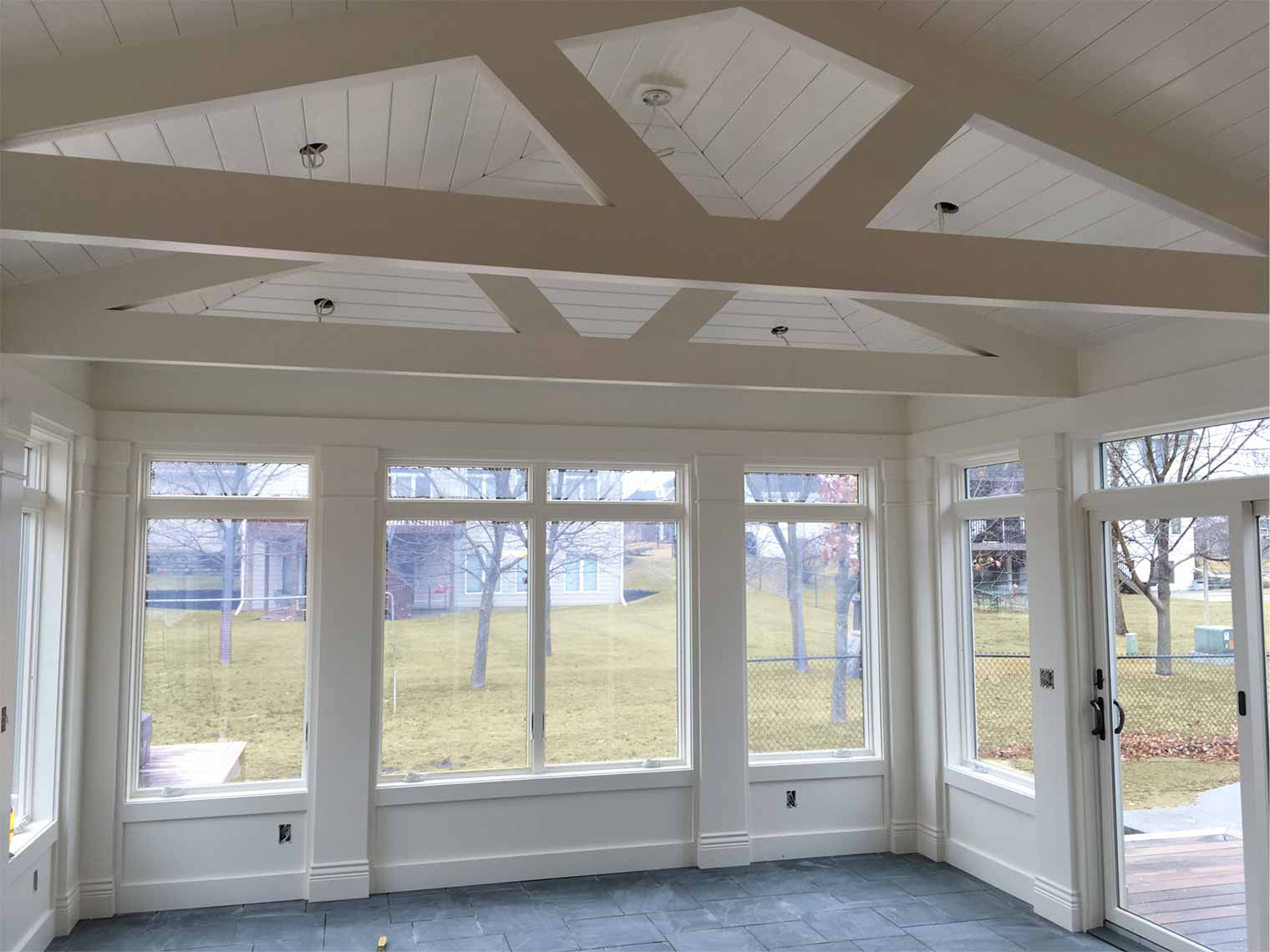 sunroom addition in Des Moines designed and being built by Silent Rivers is in progress, framing complete and walls painted Dover White with blue slate tile floors ready to be grouted