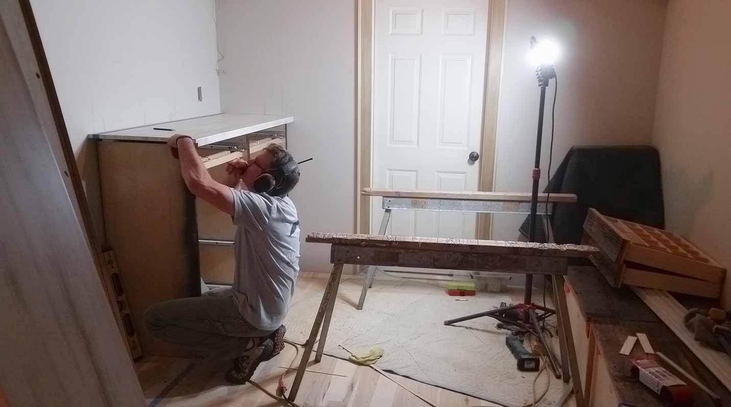John Yoder of Silent Rivers installs a custom closet cabinet and countertop in a master suite remodel in Granger, Iowa