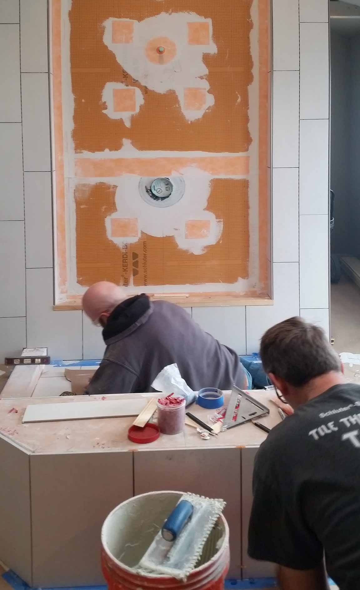 Tile installation continues around the larger three-sided shower in a master bathroom remodel in Granger, Iowa by Silent Rivers