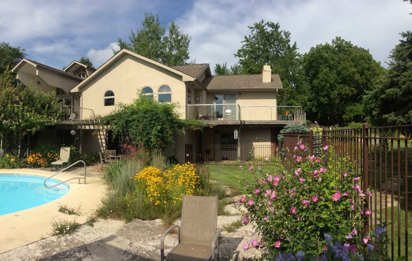 before photo of backyard oasis in rural Iowa with pool and large deck needing redesigned by Silent Rivers of Des Moines