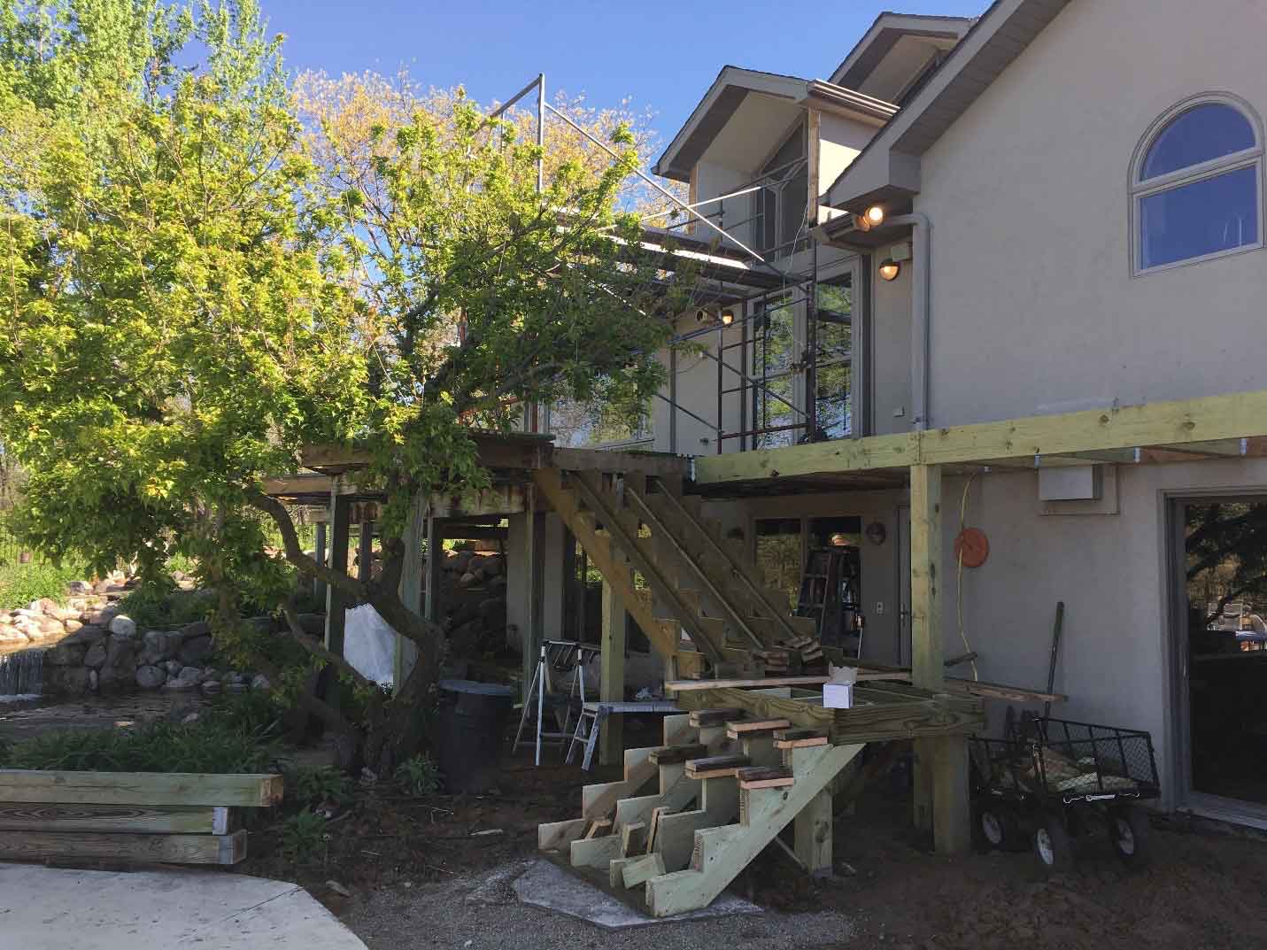 In progress photo of reduced size overhang and new catwalk being framed at rural Iowa house backyard oasis being redesigned by Silent Rivers of Des Moines