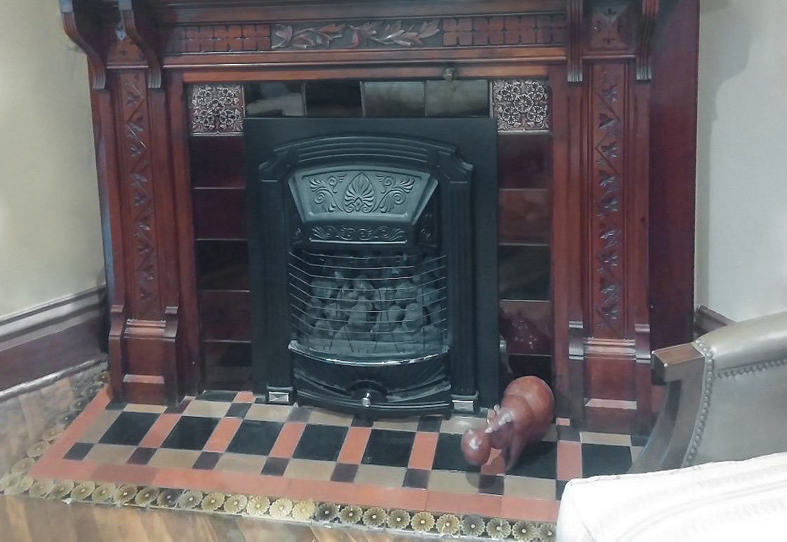 ornate fireplace with tile hearth in Victorian Des Moines home serves as inspiration for new kitchen floor tile by kitchen remodeler Silent Rivers Design+Build