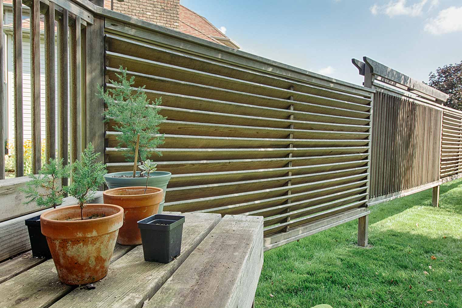 Asian style slat fence for airflow and privacy in Ames exterior remodel by Silent Rivers Des Moines