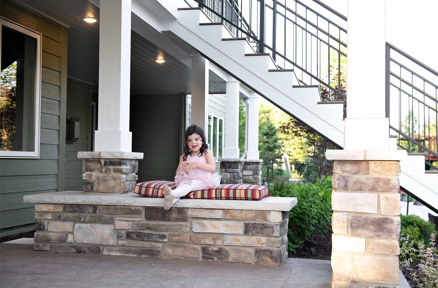 daughter sitting on integrated bench in Urbandale Iowa deck and patio by Silent Rivers