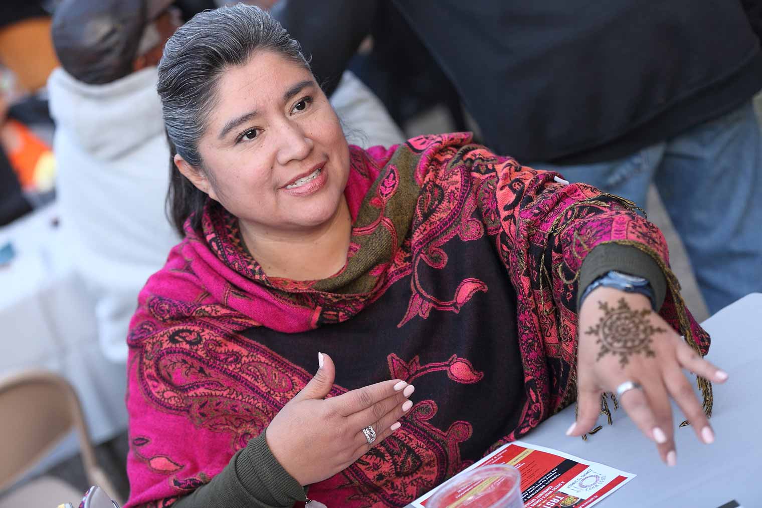 Erika Macias shows the mehendi design created on her hand by CultureALL Ambassador Sonal Mistry at Silent Rivers 25th Anniversary and dsm Unveiling